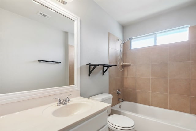 full bathroom featuring tiled shower / bath combo, vanity, and toilet