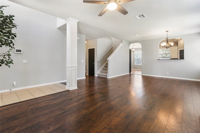 interior space featuring ceiling fan with notable chandelier, hardwood / wood-style floors, and ornate columns