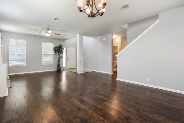 unfurnished living room with ceiling fan with notable chandelier and dark hardwood / wood-style flooring