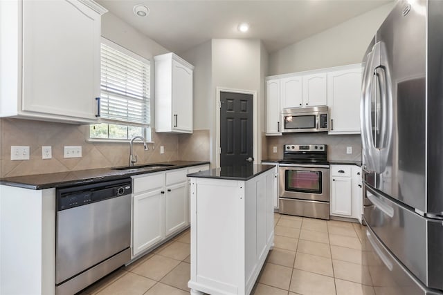 kitchen featuring white cabinets, appliances with stainless steel finishes, a kitchen island, and sink