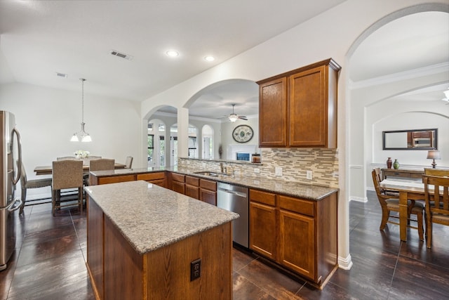 kitchen with ceiling fan with notable chandelier, appliances with stainless steel finishes, tasteful backsplash, decorative light fixtures, and kitchen peninsula