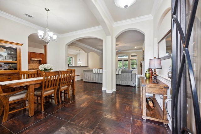 dining area with crown molding and a chandelier