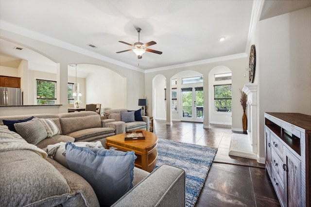 living room featuring dark tile patterned flooring, ceiling fan with notable chandelier, and ornamental molding