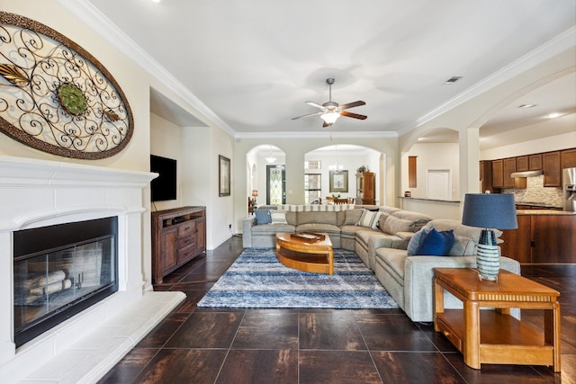 living room featuring ceiling fan with notable chandelier and ornamental molding