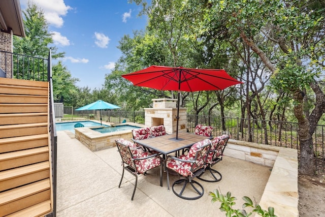 view of patio / terrace with a swimming pool with hot tub and an outdoor stone fireplace