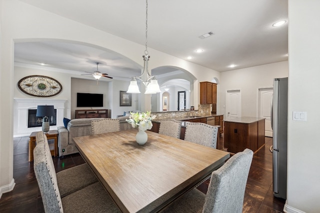 dining room featuring dark wood-type flooring and ceiling fan with notable chandelier