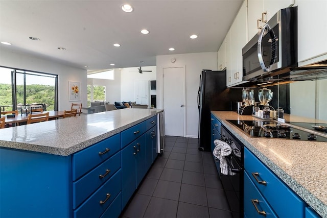 kitchen with black electric cooktop, ceiling fan, white cabinets, and blue cabinets