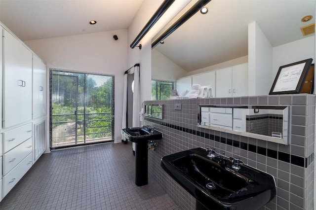 bathroom featuring tile patterned floors, tasteful backsplash, and high vaulted ceiling