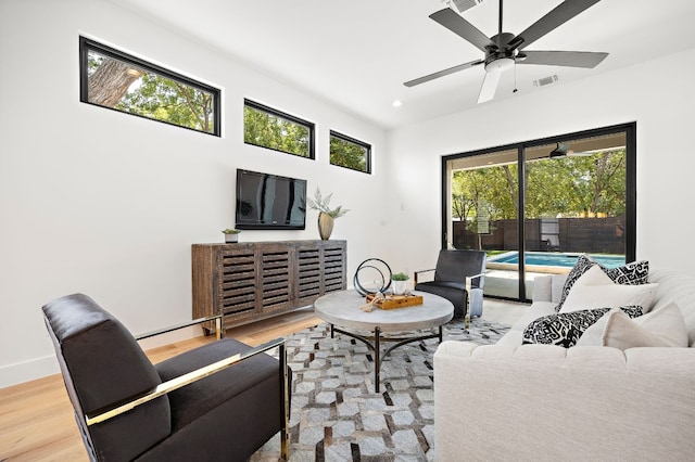 living room with hardwood / wood-style floors, a wealth of natural light, and ceiling fan