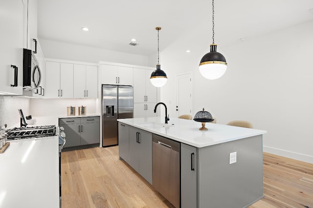 kitchen with gray cabinets, sink, an island with sink, and stainless steel appliances