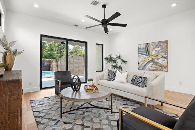 living room with ceiling fan and light hardwood / wood-style floors