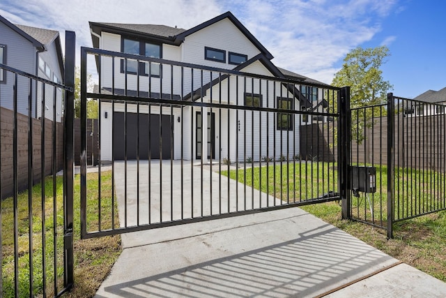 view of gate with a garage and a yard