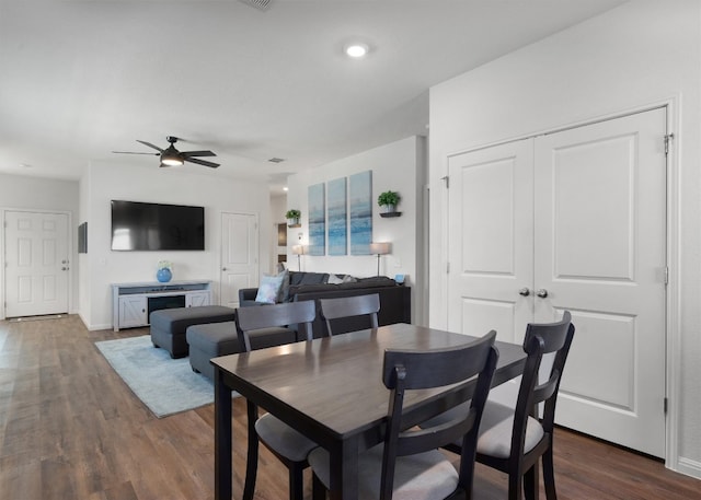 dining area with dark hardwood / wood-style floors and ceiling fan