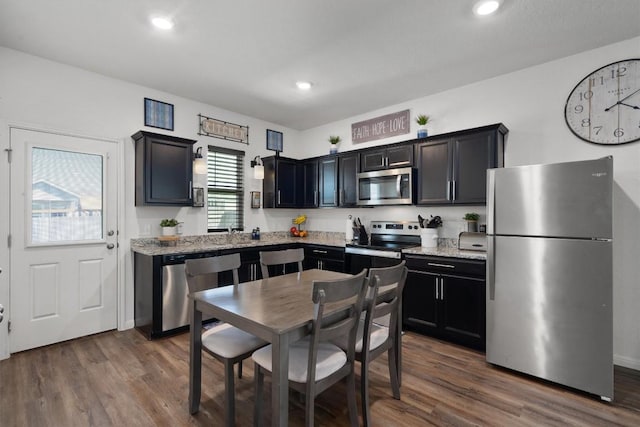 kitchen featuring light stone countertops, stainless steel appliances, and dark hardwood / wood-style floors