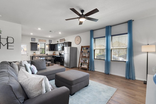 living room featuring light hardwood / wood-style flooring and ceiling fan