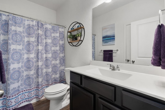 bathroom with hardwood / wood-style floors, vanity, and toilet