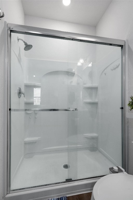 bathroom with toilet and an enclosed shower