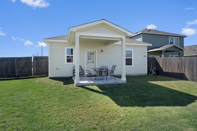 rear view of property featuring a lawn and a patio area