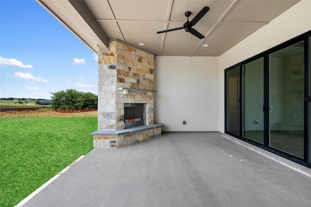 view of patio / terrace featuring ceiling fan and an outdoor stone fireplace