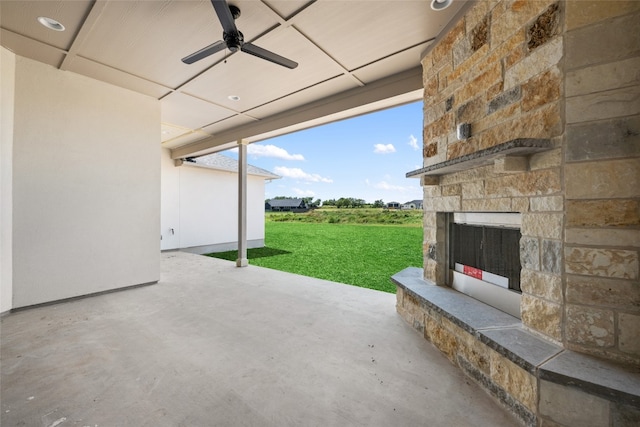 view of patio with ceiling fan and an outdoor stone fireplace