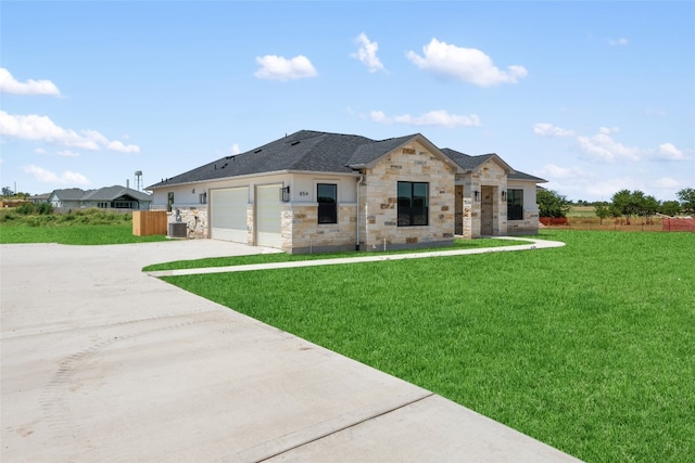 view of front facade featuring a front yard, a garage, and cooling unit