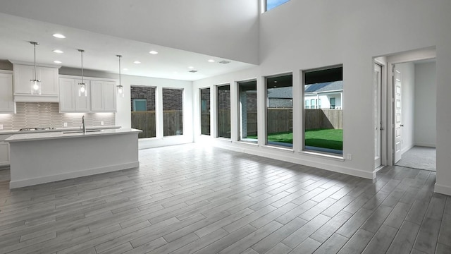 unfurnished living room featuring sink and a high ceiling