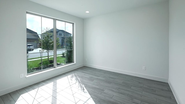 spare room with wood-type flooring and plenty of natural light