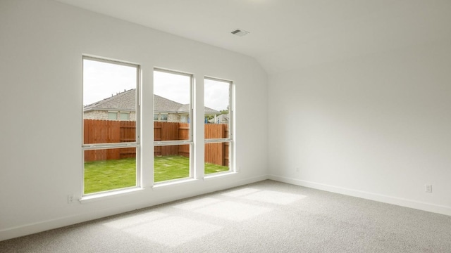 carpeted spare room with lofted ceiling