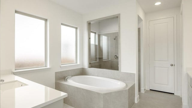 bathroom featuring tile patterned floors, plus walk in shower, and vanity