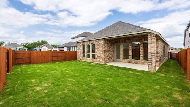 back of house with a lawn and a patio