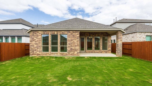 rear view of house featuring a lawn and a patio