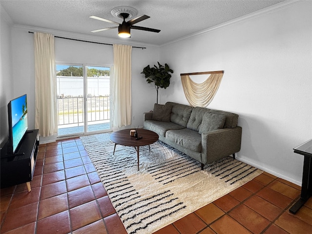 living room with a textured ceiling, dark tile patterned flooring, ceiling fan, and ornamental molding