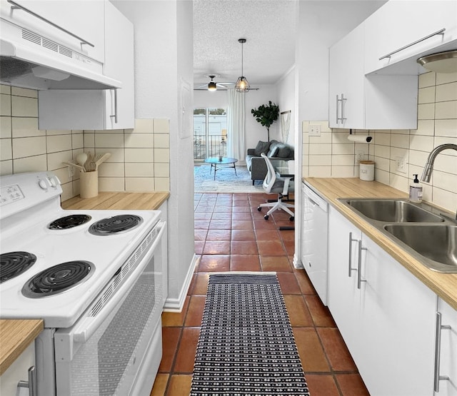 kitchen with pendant lighting, white appliances, exhaust hood, sink, and a textured ceiling