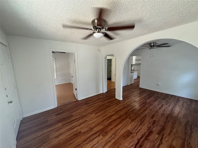 spare room with dark hardwood / wood-style flooring, ceiling fan, and a textured ceiling