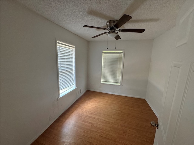 unfurnished room with a healthy amount of sunlight, a textured ceiling, ceiling fan, and light hardwood / wood-style flooring