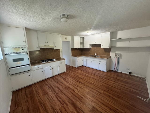 kitchen with dark hardwood / wood-style flooring, white cabinets, and backsplash