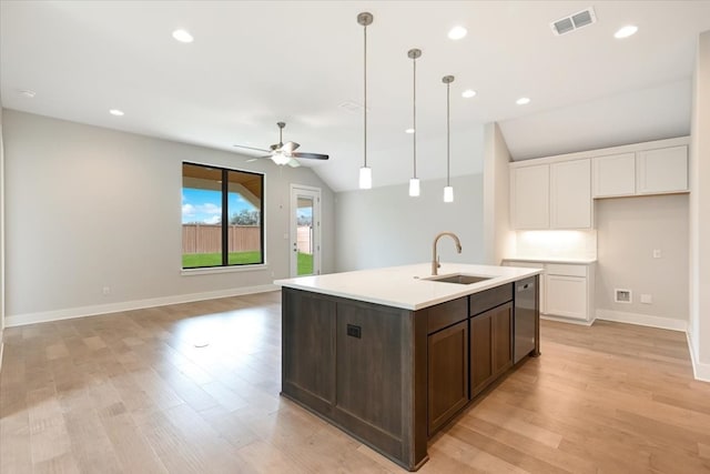 kitchen with light hardwood / wood-style flooring, an island with sink, sink, ceiling fan, and vaulted ceiling