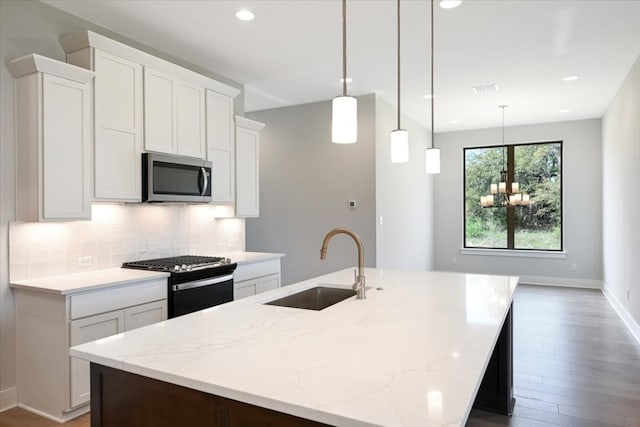 kitchen with a center island with sink, appliances with stainless steel finishes, tasteful backsplash, and hardwood / wood-style floors