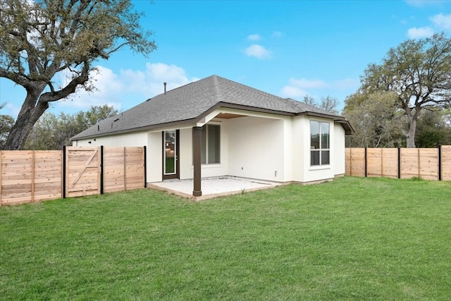 rear view of house featuring a yard and a patio area