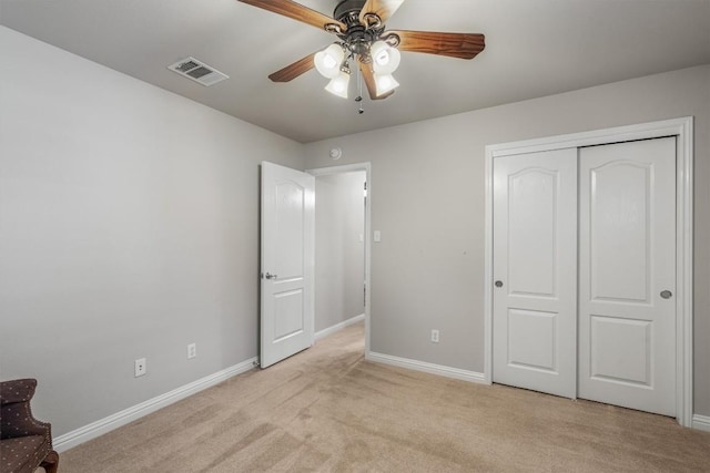 unfurnished bedroom with light carpet, a closet, and ceiling fan