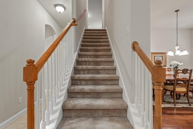 stairway featuring a chandelier