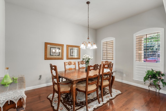 dining area featuring dark hardwood / wood-style flooring and an inviting chandelier