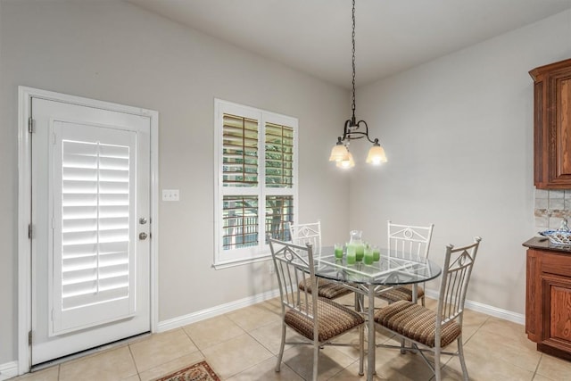 tiled dining room featuring a chandelier