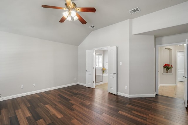 spare room featuring dark hardwood / wood-style floors, ceiling fan, and vaulted ceiling