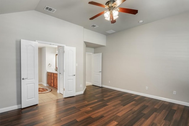 unfurnished bedroom with ceiling fan, dark hardwood / wood-style floors, and vaulted ceiling