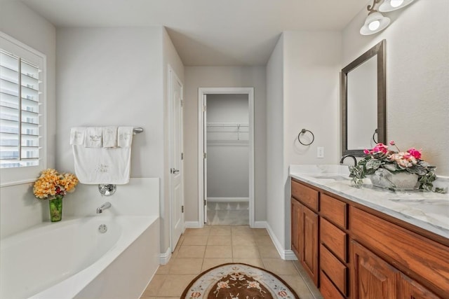 bathroom with tile patterned floors, a tub, and vanity