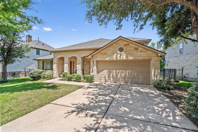 1102 Winding Creek Pl, Round Rock, TX 78665 - view of front of home with concrete driveway, a front lawn, stone siding, an attached garage, and fence