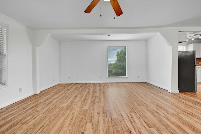 unfurnished living room featuring ceiling fan, track lighting, and light hardwood / wood-style floors