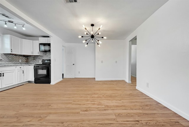 kitchen with an inviting chandelier, backsplash, black appliances, and white cabinets