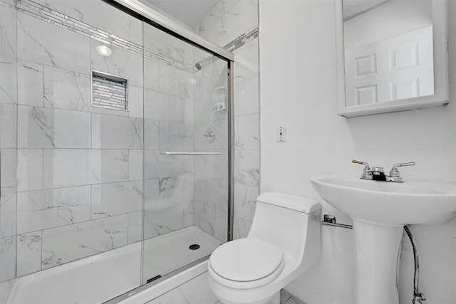 bathroom with a shower with door, sink, tile patterned floors, and toilet